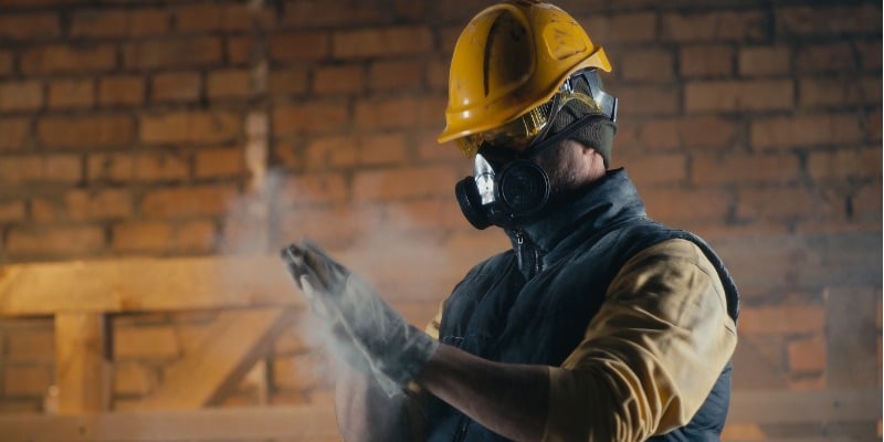 Male builder on site wearing a reusable respirator
