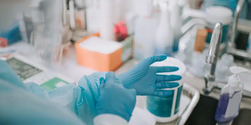 Female dentist putting on gloves