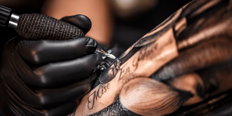 Tattoo artist at work close up - Tattoo Parlour Supplies: Your Complete Guide to Sanitary & Safe Practices