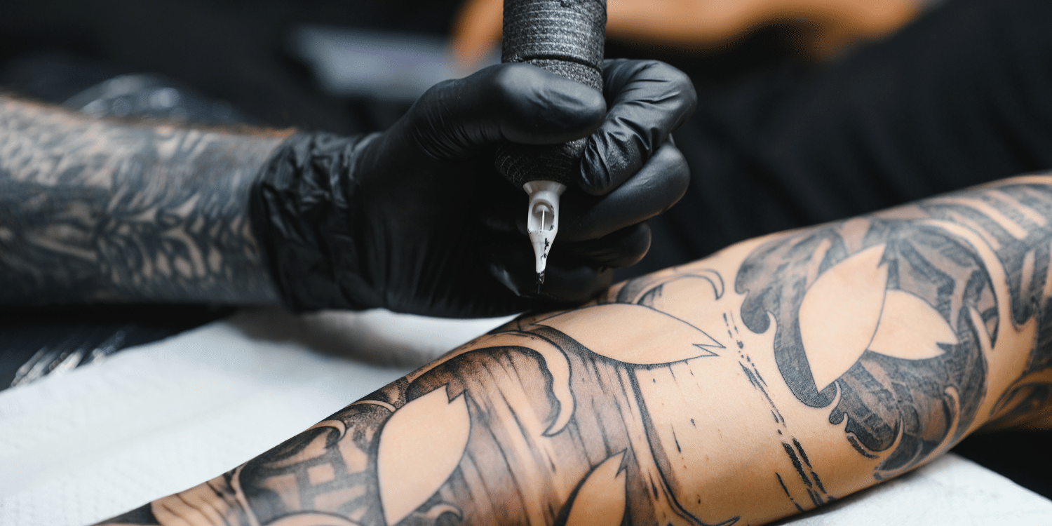 Tattoo artist at work close up of needle and work - Tattoo Parlour Supplies: Your Complete Guide to Sanitary & Safe Practices